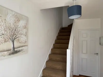 a staircase in a home with a painting on the wall at 3 bedrooms house in Stevenage