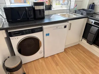 a kitchen with a washing machine and a microwave at 3 bedrooms house in Stevenage
