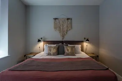 a bedroom with a large bed with two lamps at 2BR Apartments in Southend near City Centre in Southend-on-Sea