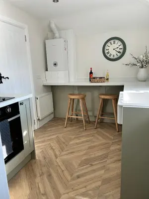 a kitchen with a counter and a clock on the wall at Historic Retreat Near To Mersea Island in Peldon