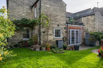 an exterior view of a brick house with a yard at Elegant Period House in the Historic Heart of Cambridge - sleeps 12 in Cambridge