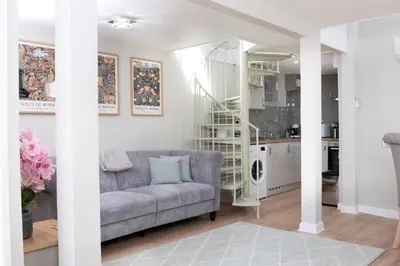 a living room with a couch and a kitchen at Horseshoe house in Sudbury