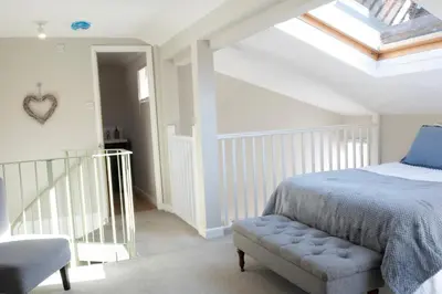 a bedroom with a bed and a chair and a skylight at Horseshoe house in Sudbury