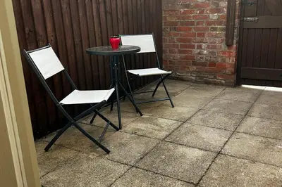 two chairs and a table with a drink on it at Horseshoe house in Sudbury
