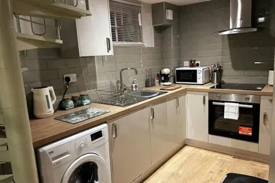 a kitchen with a washing machine and a microwave at Horseshoe house in Sudbury