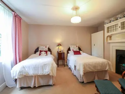 a bedroom with two beds and a fireplace at Curry Farm in Southminster