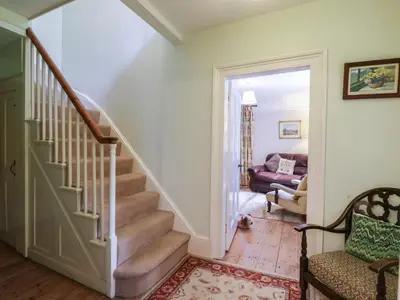 a hallway with stairs and a living room at Curry Farm in Southminster