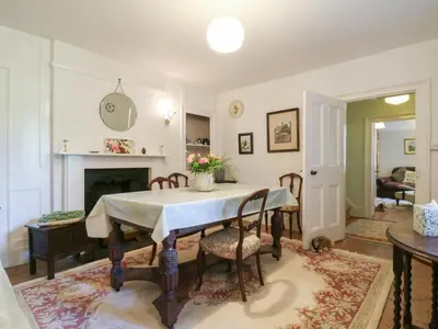 a dining room with a table and chairs and a fireplace at Curry Farm in Southminster