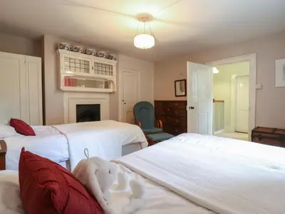 a bedroom with two beds and a fireplace at Curry Farm in Southminster