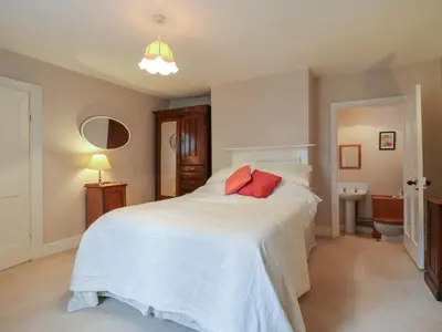 a bedroom with a white bed with two red pillows at Curry Farm in Southminster