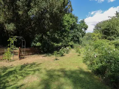 a garden with a fence and trees and grass at Curry Farm in Southminster
