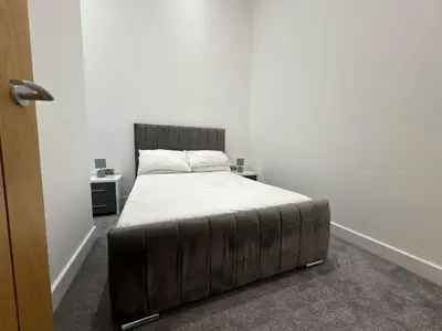 a bedroom with a large bed with a wooden headboard at Amazing 3-bedroom in Great Warley, Brentwood in Great Warley Street