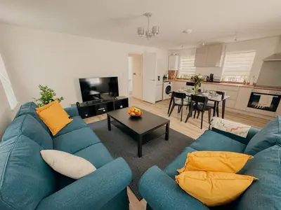 a living room with a blue couch and a table at Modern Stay - Walk to Everything 1 in Ipswich