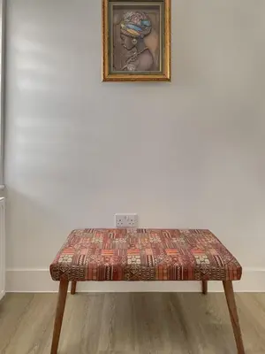 a bench in front of a white wall with a picture at Modern Stay - Walk to Everything 1 in Ipswich