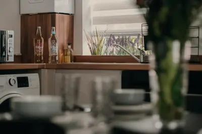 a kitchen with bottles and dishes on a counter at Modern Stay - Walk to Everything 1 in Ipswich