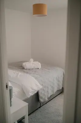 a white bed with a white towel on top of it at Modern Stay - Walk to Everything 4 in Ipswich