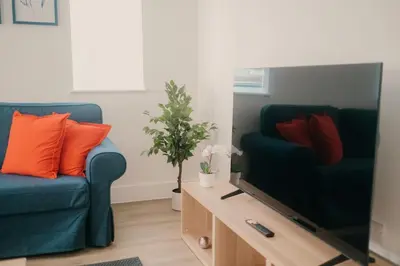 a living room with two blue chairs and a television at Modern Stay - Walk to Everything 4 in Ipswich