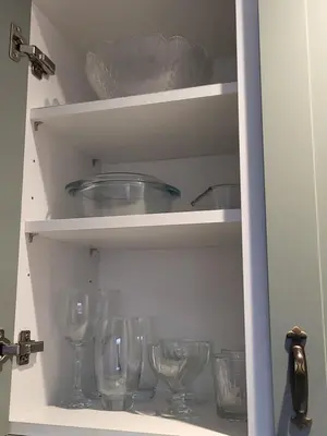 a cupboard filled with empty glasses and bowls at Cozy Studio Newly Furnished in Colchester