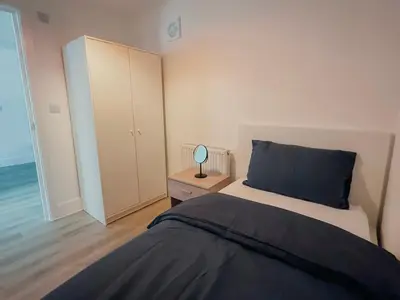 a bedroom with a bed and a room with the ocean at Modern Stay - Walk to Everything 2 in Ipswich