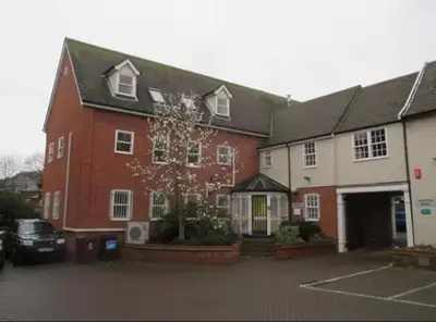 a large red and white building with a parking lot at Modern Stay - Walk to Everything 2 in Ipswich