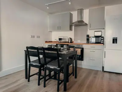 a kitchen with a black table and black chairs at Modern Stay - Walk to Everything 2 in Ipswich