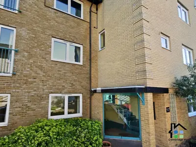 a brick building with windows and bushes in front of it at CB Stays - 2 Bedroom & 2 Toilet Flat - Near Mills Road and Train Station with Parking in Cambridge