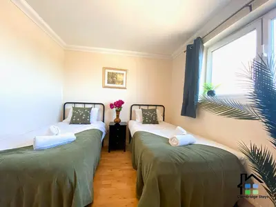 two twin beds in a room with a window at CB Stays - 2 Bedroom & 2 Toilet Flat - Near Mills Road and Train Station with Parking in Cambridge