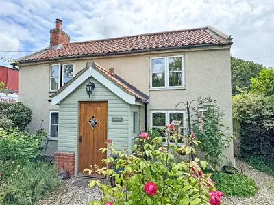 a white house with a brown door and a garden at Hill House in Snape
