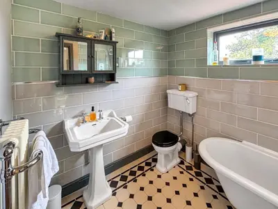 a bathroom with a sink and a toilet and a tub at Hill House in Snape