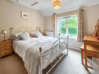 a bedroom with a white bed and a window at Hill House in Snape