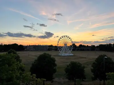 a ferris wheel in a field at sunset at Modern Central Apartment with Parking in Cambridge
