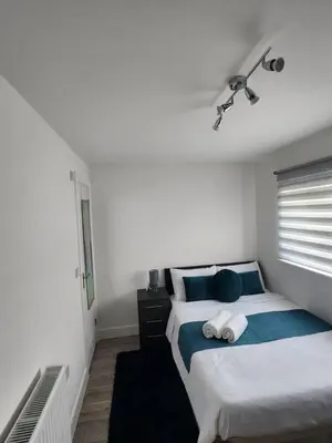 a bedroom with two beds and a window at Ensuite deluxe home in Basildon