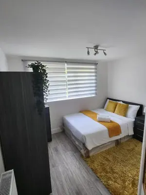 a bedroom with a bed and a window at Ensuite deluxe home in Basildon