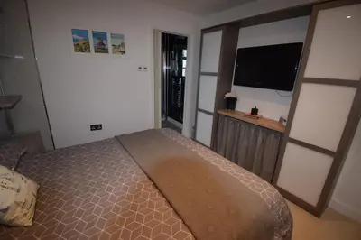 a bedroom with a bed and a flat screen tv at Eco Deco in Frinton-on-Sea
