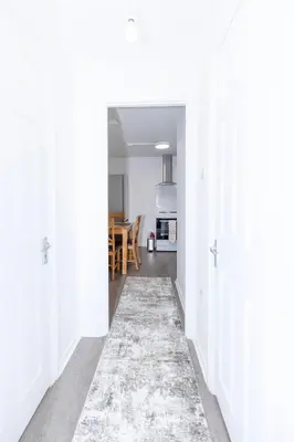 a hallway with white walls and a rug at Urban Escape - Flat in Brandon