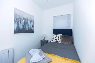 a bedroom with a bed and a picture on the wall at Urban Escape - Flat in Brandon
