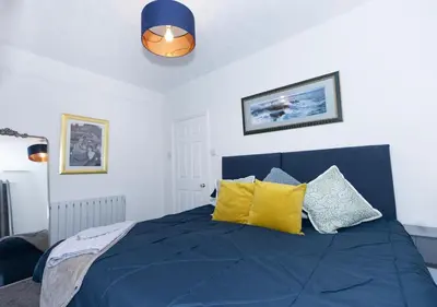 a bedroom with a blue bed with yellow pillows at Urban Escape - Flat in Brandon