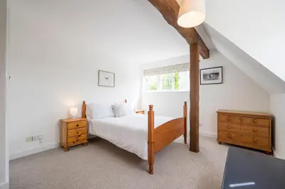 a bedroom with a large bed and a window at Hollybank Cottage, Ufford in Ufford