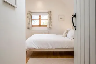 a bedroom with a bed and a window at Hollybank Cottage, Ufford in Ufford