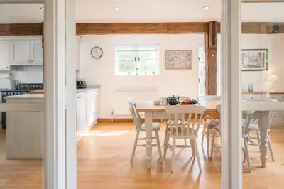a kitchen and dining room with a table and chairs at Hollybank Cottage, Ufford in Ufford