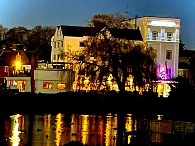 a building with a tree in front of the water at Valley View in Sudbury