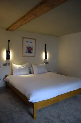 a large white bed in a room with two lights at Alma Inn & Dining Rooms in Harwich