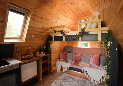 a tiny house with a couch in a room at Sycamore Lodge with Hot Tub- Quirky & Romantic in Halstead