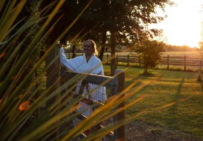 a woman is sitting on a swing at Sycamore Lodge with Hot Tub- Quirky & Romantic in Halstead