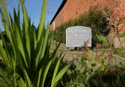 a sign in front of a brick building at Sycamore Lodge with Hot Tub- Quirky & Romantic in Halstead