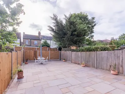 a backyard with a wooden fence and a patio at Pass the Keys Comfortable Flat with Patio Sleeps 4 in Westcliff On Sea