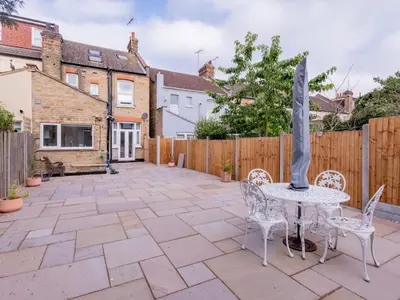 a patio with a table and chairs and a fence at Pass the Keys Comfortable Flat with Patio Sleeps 4 in Westcliff On Sea