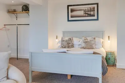 a living room with a white bed and a couch at Studio Lodge with parking - Stansted airport in Hatfield Broad Oak