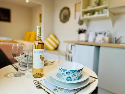 a bottle of wine sitting on a table with a glass at Unique Suffolk Cabin with Countryside Views in Burgh
