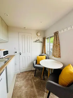 a kitchen and living room with a table and chairs at Unique Suffolk Cabin with Countryside Views in Burgh